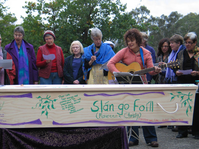 women closeup sing 'Bread and Roses' to Caty, wi
