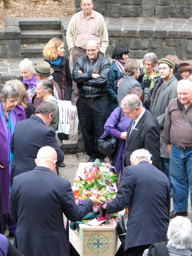 flower laden coffin being lifted, Caty has to go